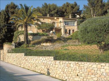 Vue d'ensemble de la façade sud avec jardin au premier plan.