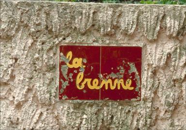 Nom de villa inscrit sur plaque en céramique vernissée.