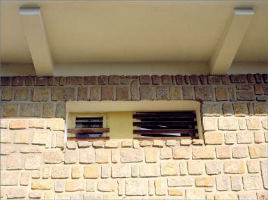 Grilles en fer-forgé et mur appareillé, au rez-de-chaussée, sur façade sud.