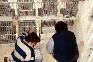 Vue intrieure de la chambre du four industriel  bois. Matriel d'enfournement. Pose des manchons rfractaires. Encabanage des carreaux  l'aide de briques.