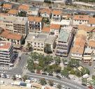 Vue arienne de la place Ernest Reyer avec mairie au second plan, depuis le sud.